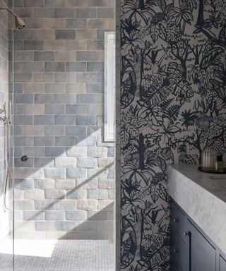 Bathroom with grey stone effect tiles and botanical pattern wallpaper