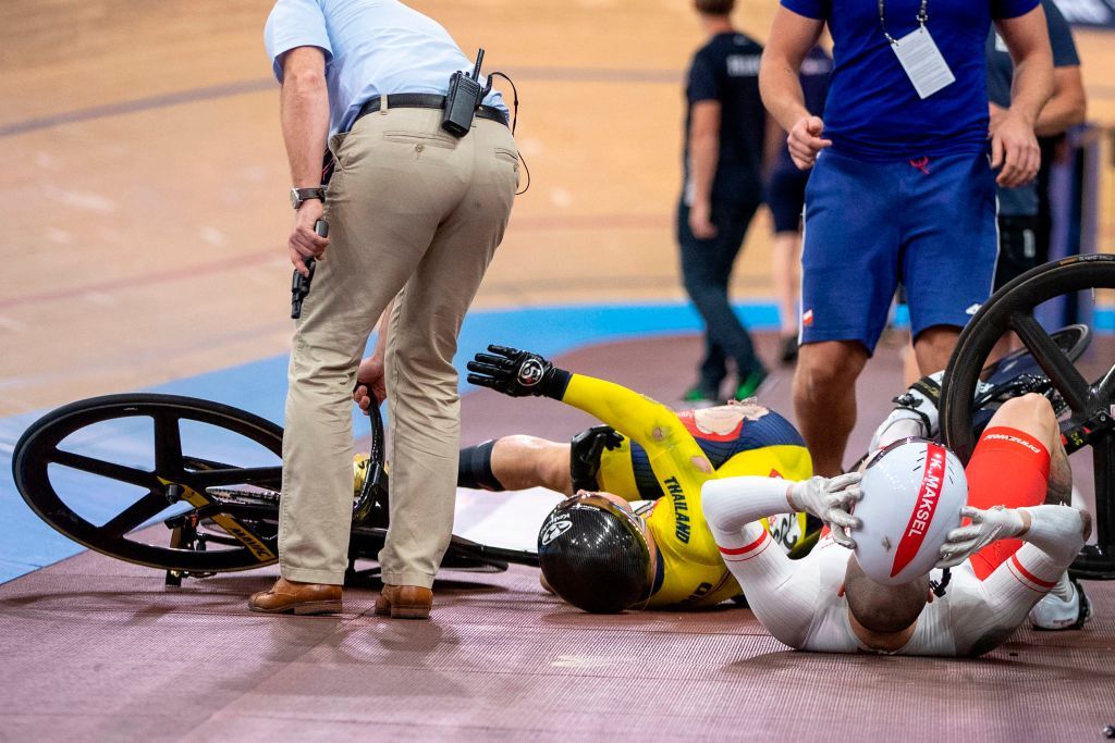 Thailands Jai Angsuthasawit C and Polands Krzysztof Maksel R receive help from a race official still holding the starter pistol following a crash during the Kerin quarter final race at the UCI track cycling World Championship at the velodrome in Berlin on February 27 2020 Photo by Odd ANDERSEN AFP Photo by ODD ANDERSENAFP via Getty Images