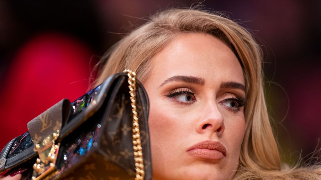 los angeles, ca october 19 singer adele uses her purse to hide from the tv camera while she sings along to her song being played to the audience while attending a game between the golden state warriors and the los angeles lakers on october 19, 2021 at staples center in los angeles allen j schaben los angeles times via getty images