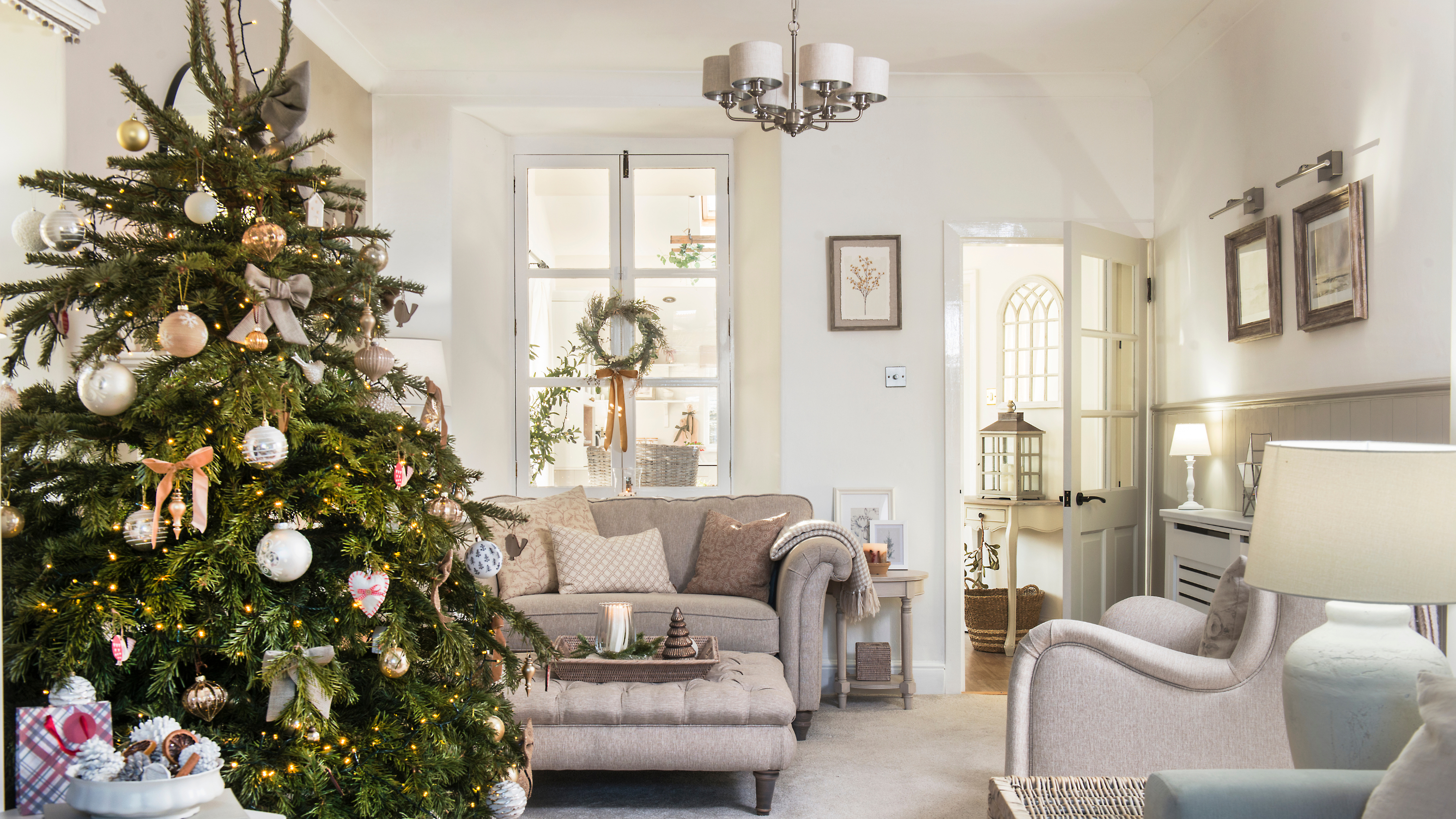 Real Christmas tree decorated in a neutral living room.