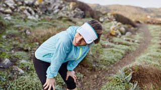 woman stopping for a rest during a trail run