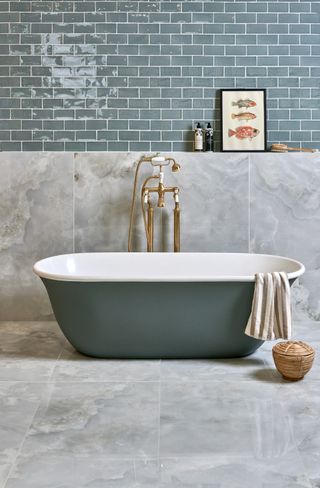 A bathroom with a freestanding bath and large format floor and wall tiles