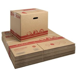 A stack of unfolded cardboard boxes with one made up carboard box sitting on top 