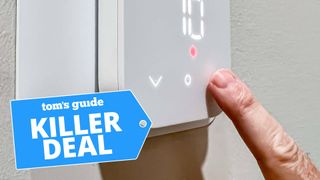 A photo of a person using the Amazon Smart Thermostat, with the "Tom's Guide Killer Deal" tag overlaid