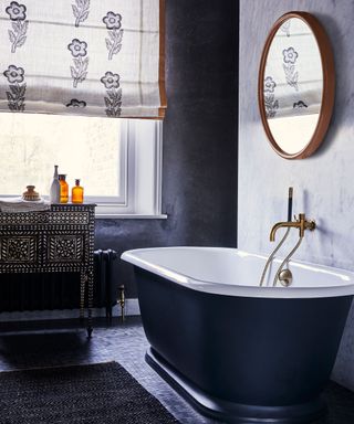 Window treatment idea in a bathroom with black rolltop bath