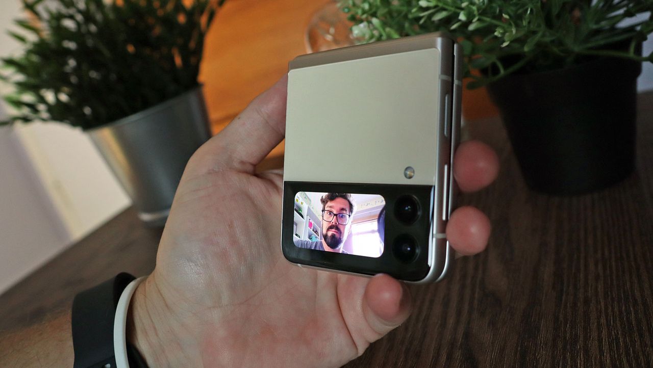 A Samsung Galaxy Z Flip 3 in someone's hand, with the secondary screen on