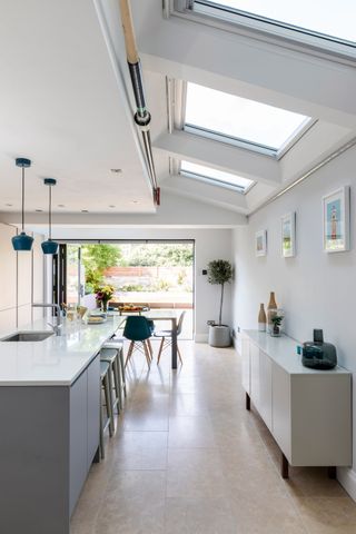 modern open plan kitchen diner with rooflights and a kitchen island