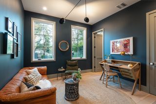 dark blue home office with tan leather sofa by Diaz + Alexander Studio