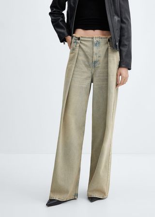 model wears jeans with a fun pleat 