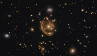This image, taken by the NASA/ESA Hubble Space Telescope, shows the Einstein ring GAL-CLUS-022058s. Einstein rings are created when the light from distant objects like galaxies pass by an extremely massive object. Because of the process known as gravitational lensing, this light is bent and distorted into this amazing, bright curve or "ring." Scientists can use these rings to study galaxies that might otherwise be too faint or far away to see.