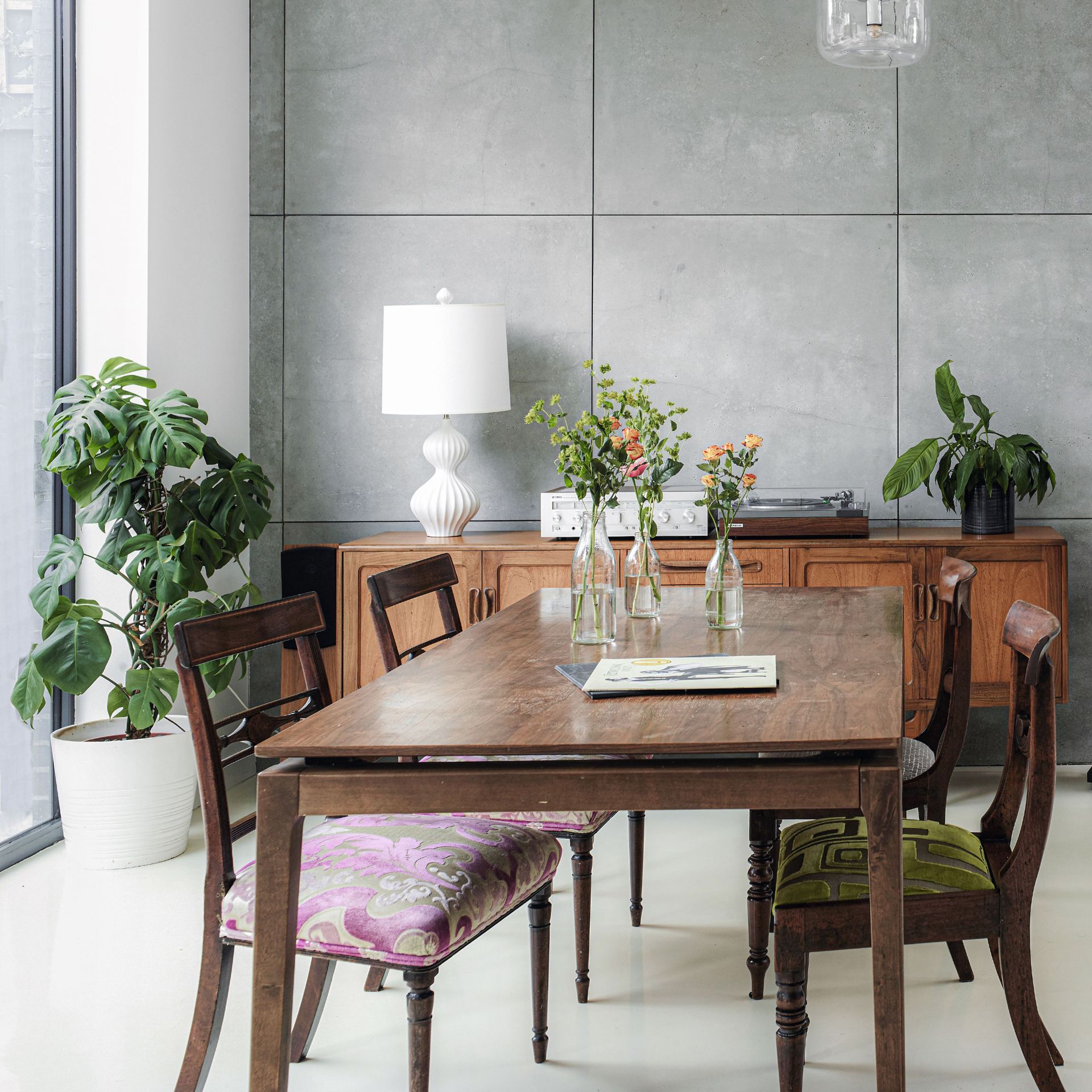 Dark wood dining table and chairs with decorative console table and plant