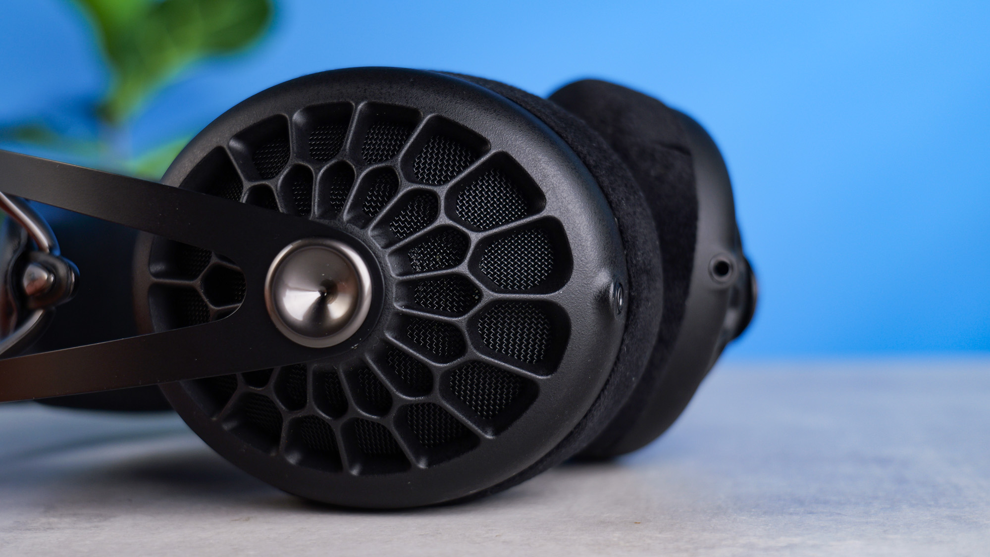 The Meze 105 AER on their side on a stone surface with a blue backround