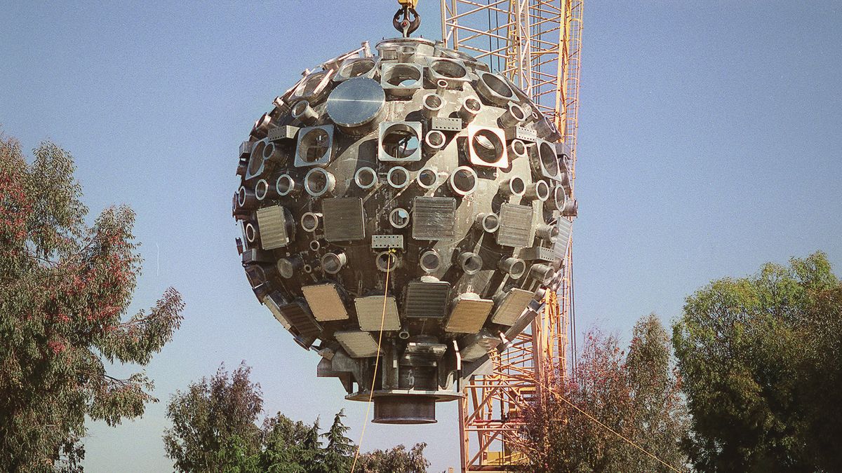 A rotating crane hoisting the target chamber into place