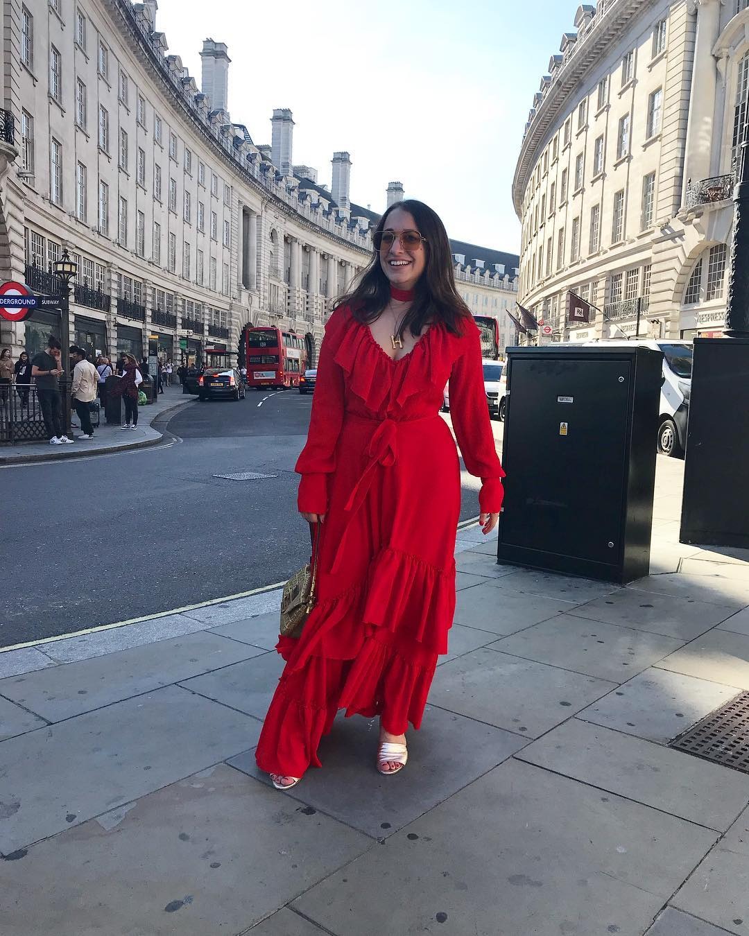 Woman wears red dress, white heels and sunglasses