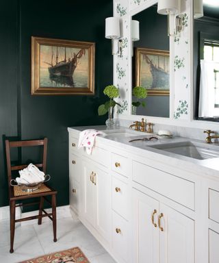 An example of how to make a small bathroom look bigger showing dark green and floral bathroom with a cream vanity unit