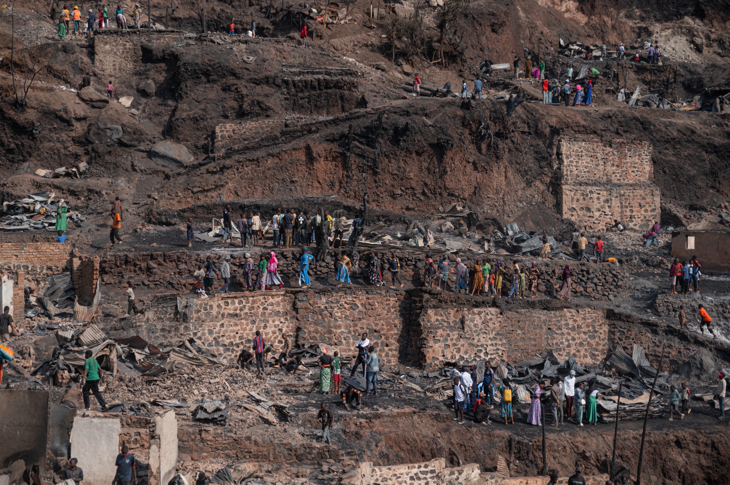 General view of residents from neighboring areas walking past the site of the fire and observe the damage caused by the blaze, which destroyed around 500 homes and killed 29 people, including pupils and teachers, in Bukavu, on September 11, 2026