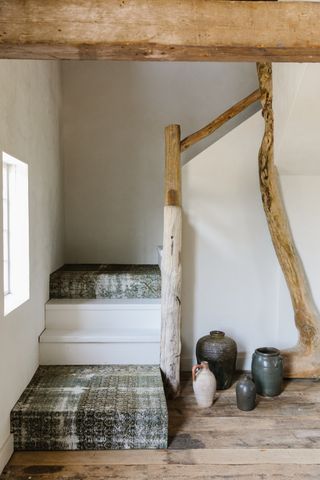 A wooden staircase with two treads upholstered in vintage rugs