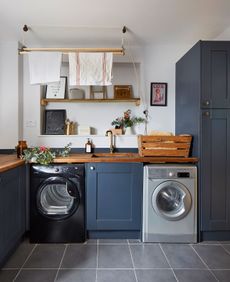 navy blue kitchen units with a washing machine and tumble dryer, sink and pulley maid drying rack as an idea for designing a utility room 