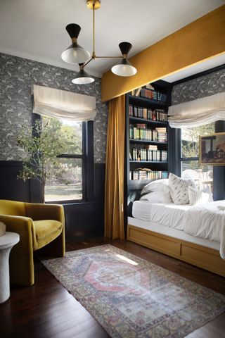 Navy bedroom with hare wallpaper and a nook bed with a yellow curtain