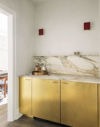A kitchen with gold-toned lower cabinets