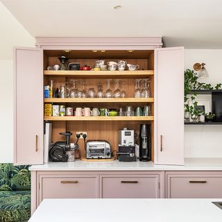 Pink kitchen with large double door pantry.