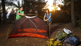 Couple pitching a tent on a backpacking trip in the mountains