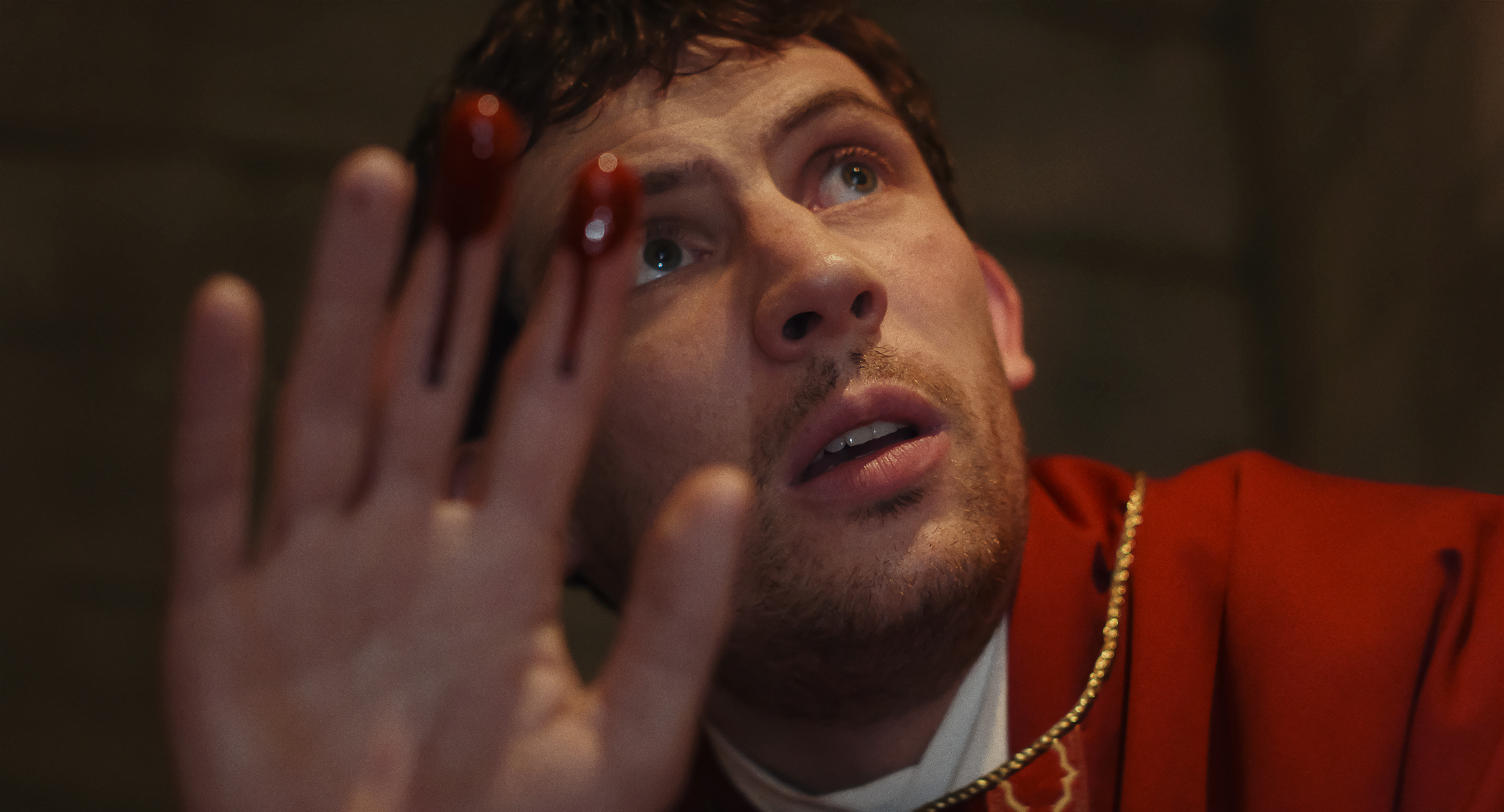 josh oconnor as a priest with blood on his fingers in knives out 3 wake up dead man
