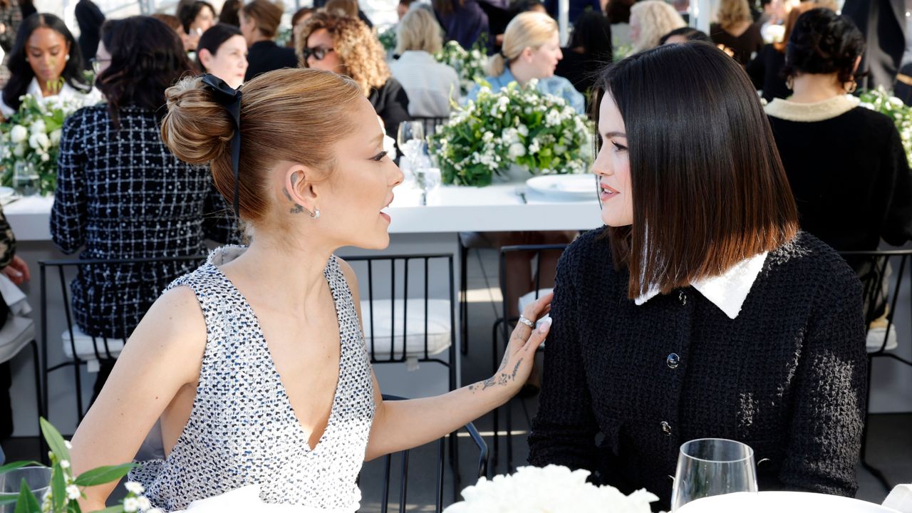 Ariana Grande and Selena Gomez sit together at a luncheon where they discuss film and fashion while wearing tweed Chanel outfits