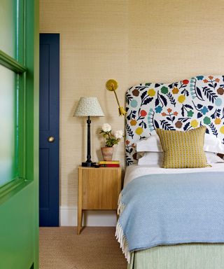 bedroom with grasscloth wallcovering and bed with patterned headboard