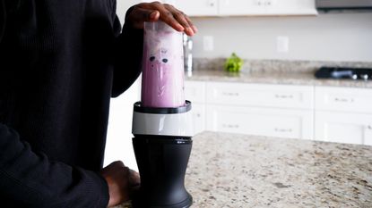 quietest blender - A blueberry smoothie on a stone marble countertop in a white kitchen