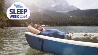 A man in a blue shirt lies in a canoe on a still lake while using the military sleep method technique to fall asleep in 2 minutes