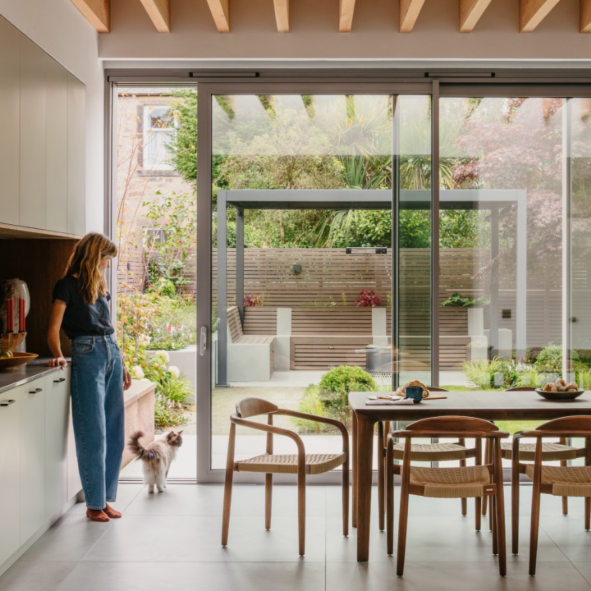 kitchen dining space with long table, chairs, view to garden