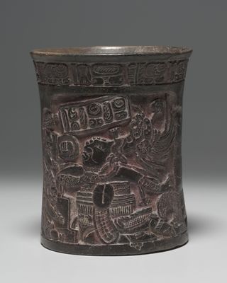 A Maya vessel, dating from about A.D. 600-1000, that shows a Maya ballplayer wearing a thick protector to shield his torso from injury. The ballplayer dives to intercept the ball, which hovers in front of his face.