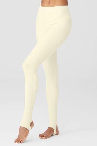 light yellow leggings from the alo yoga sale with a bar hooked under the foot for extra security