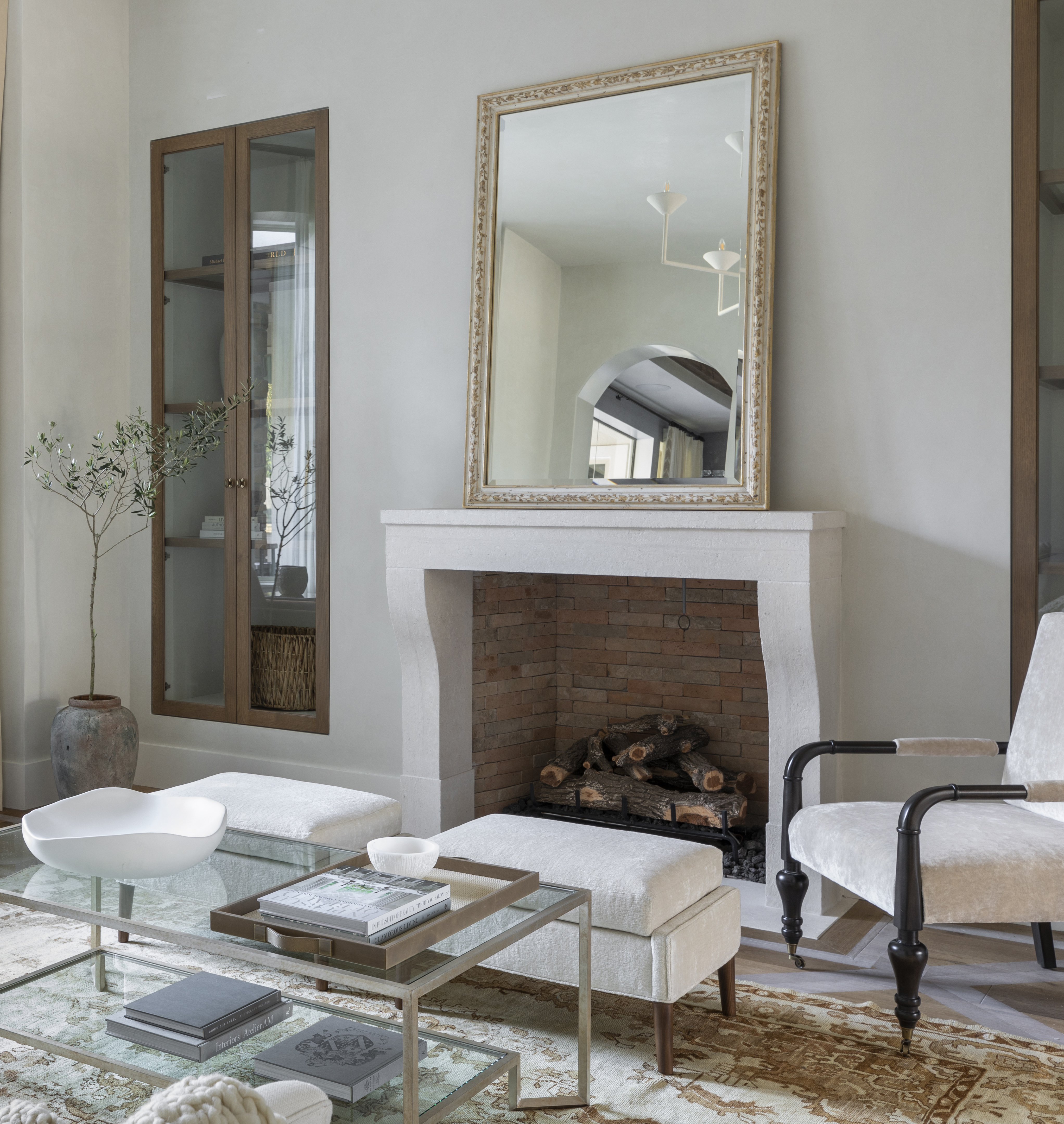 A living room with a glass cabinet built in next to the fireplace