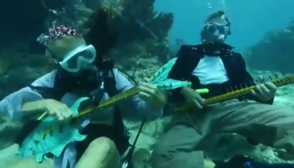 Watch hundreds of divers joyfully rock out at an underwater music festival