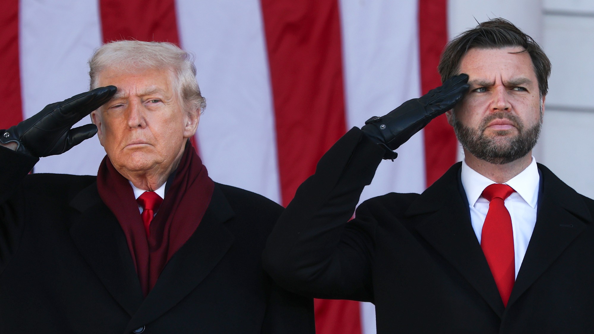 President Donald Trump and Vice President JD Vance salute during a ceremony at Memorial Amphitheater at Arlington National Cemetery to mark Veterans Day on November 11, 2025