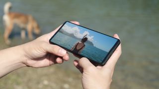 Sony Xperia 1 VI being held and showing a beach scene on screen