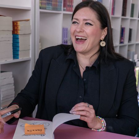 Author Callie Hart signs a book and smiles while attending the Los Angeles Times Festival of Books used for a story explaining everything we know about the quicksilver movie adaptation