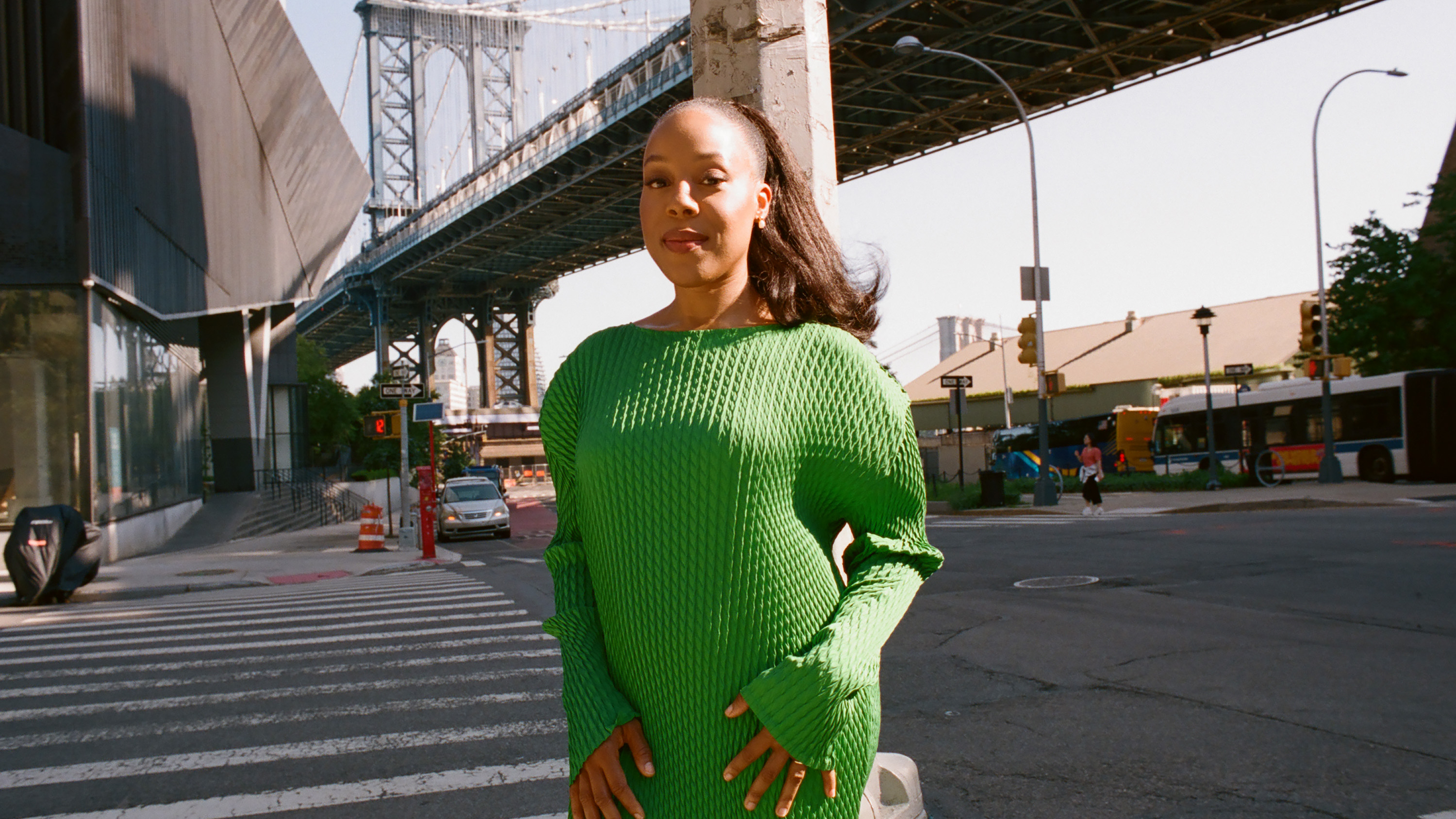 Orion Pictures president Alana Mayo wears a green sweater dress while posing in front of a New York City intersection.