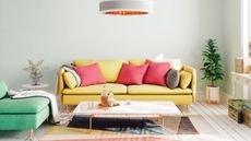 A colorful living room with a yellow sofa and coffee table