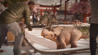 A visitor has an encounter with a baby triceratops in Jurassic World Evolution 3