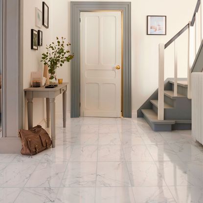 room with ceramic floor tiles and stair case and white door