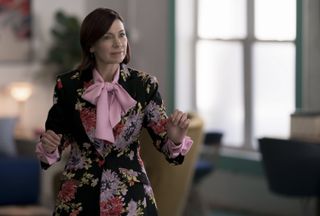 carrie preston as elsbeth wearing a floral pattern suit and a pink bow on the tv show