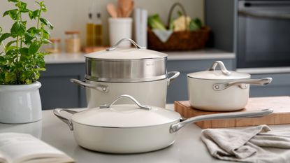 A white kitchen with hanging copper pots