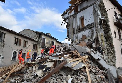 Rescuers dig through rubble in Arquata del Tronto, Italy, after major quake