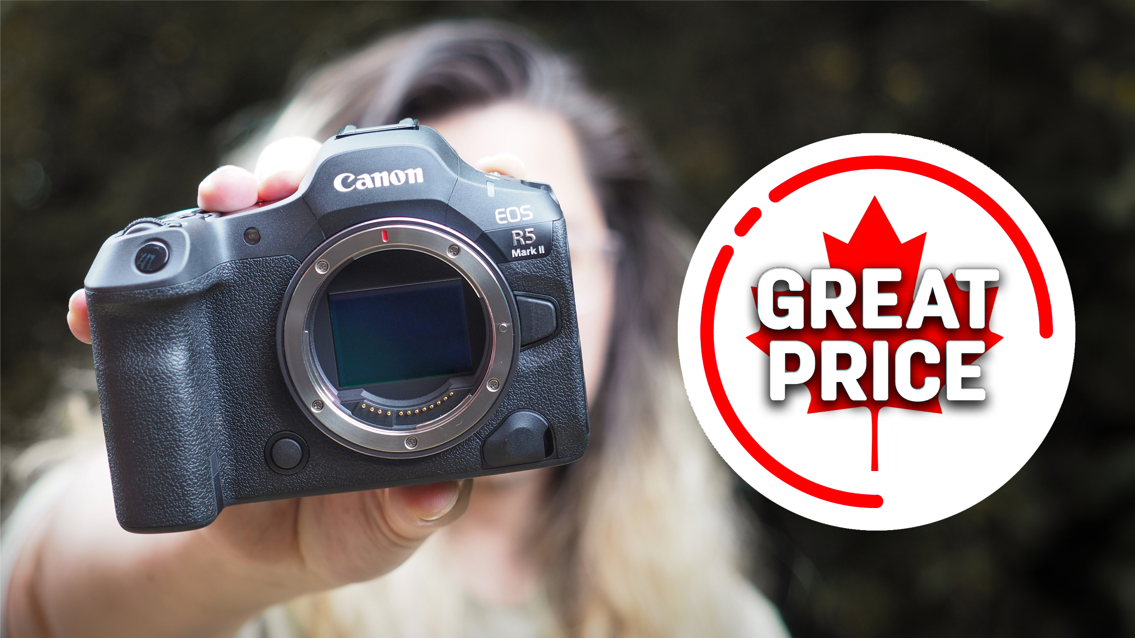 Photographer holding up a Canon EOS R5 Mark II, next to the text &quot;Great price&quot;