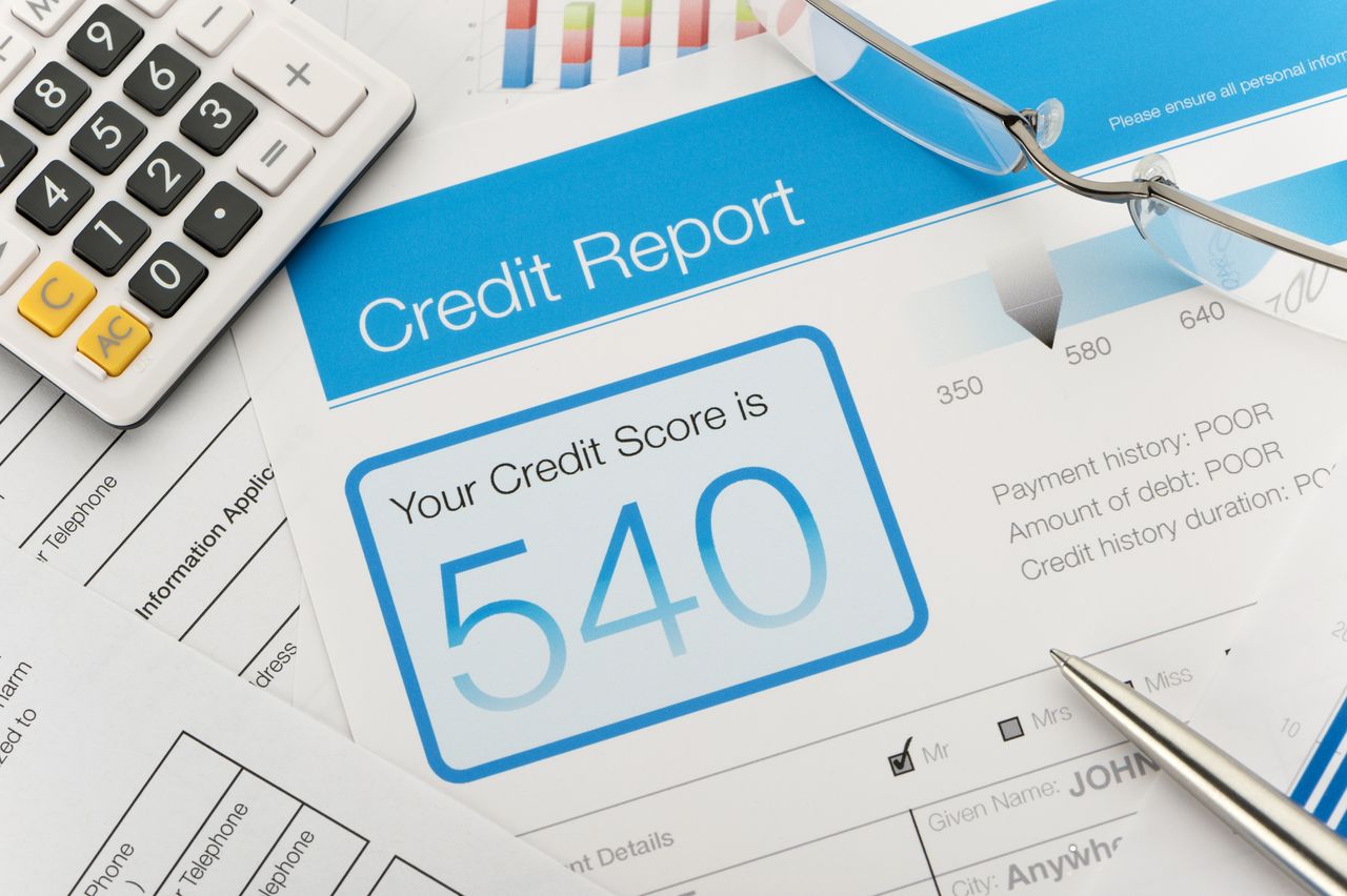 Credit report with a &quot;bad&quot; score of 540 on a desk.