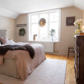 Christmas bedroom with window decoration, wreath and furry bed throw