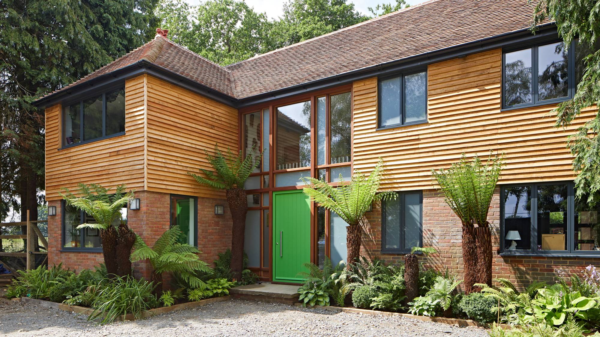 Large house with timber cladding and green composite front door